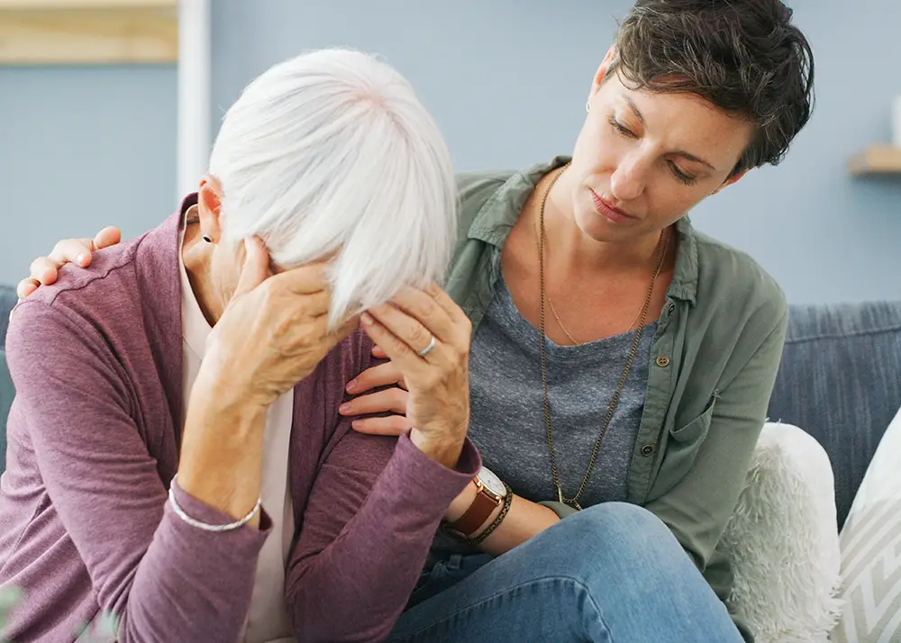elderly woman showing early signs of dementia confusion while caregiver provides emotional support