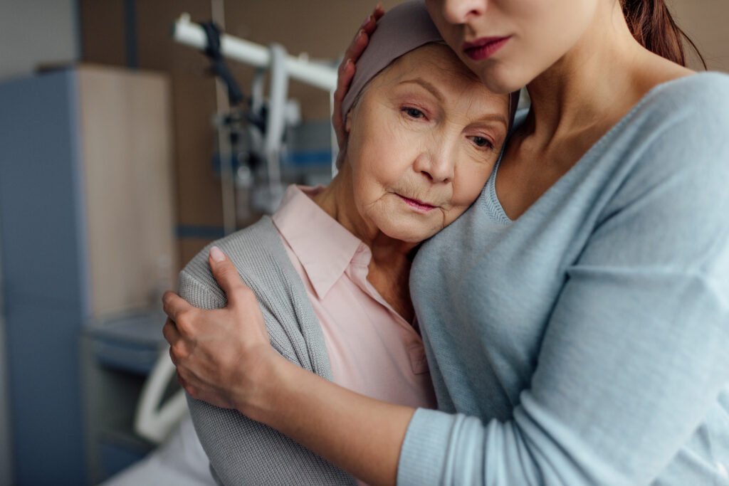Daughter embracing elderly mother during terminal illness and end-of-life support