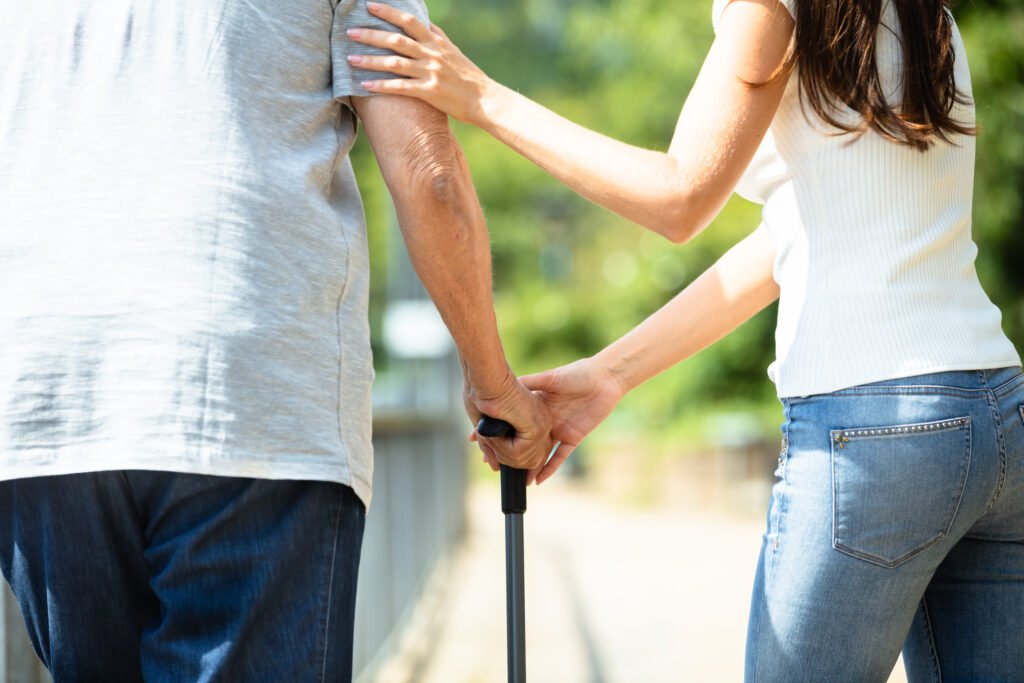 Adult daughter helping elderly parent with mobility support signs an aging parent needs more care
