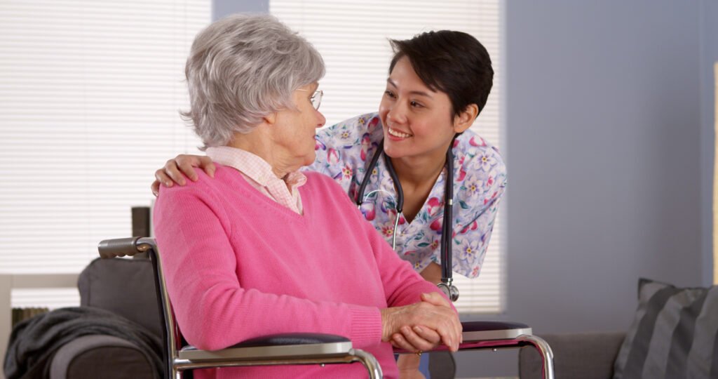 Questions to Ask When Touring Assisted Living: Compassionate caregiver assisting an assisted living resident