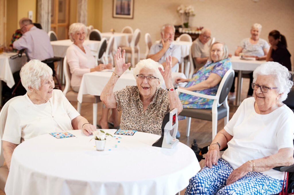 Residents participating in a bingo game together in an assisted living community activity room.