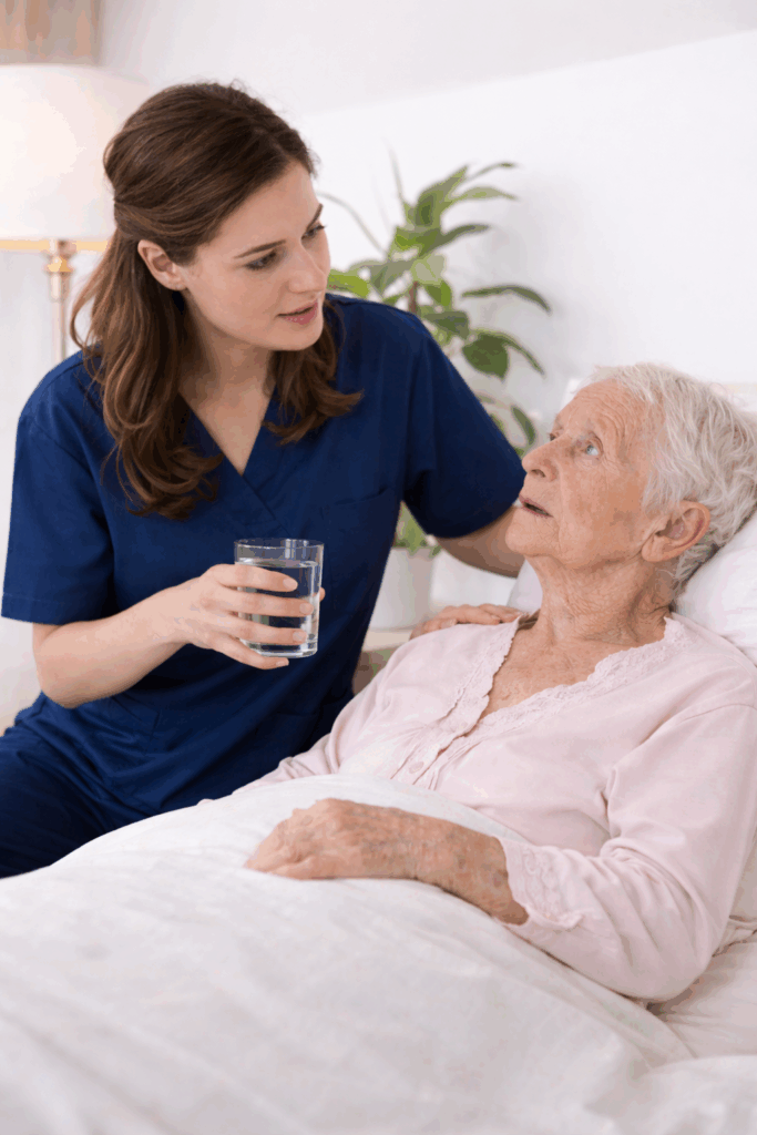 Caregiver providing hospice care support to elderly woman with dementia in a memory care setting