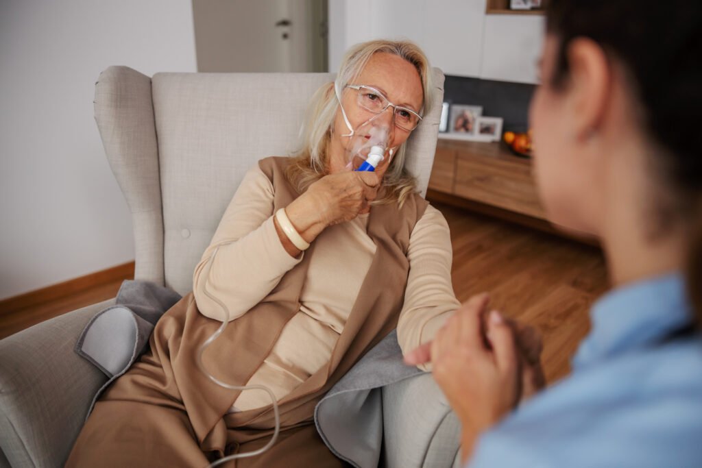 nursing home medical care elderly patient receiving respiratory support from caregiver