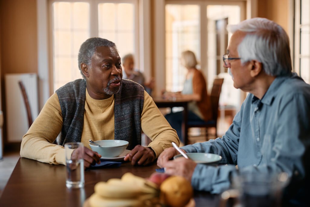 assisted living residents talking and dining together during mealtime