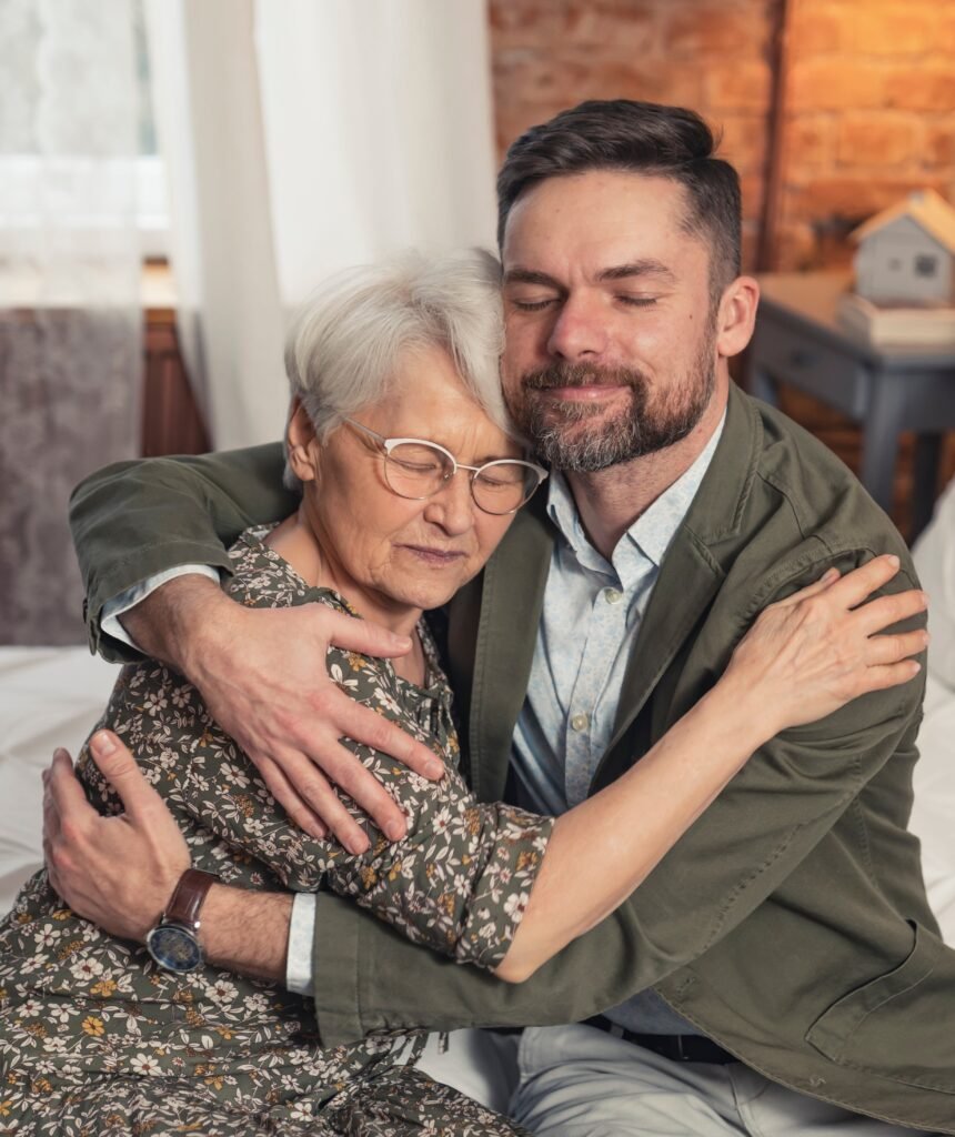 adult son hugging his elderly mother discussing healthcare decisions