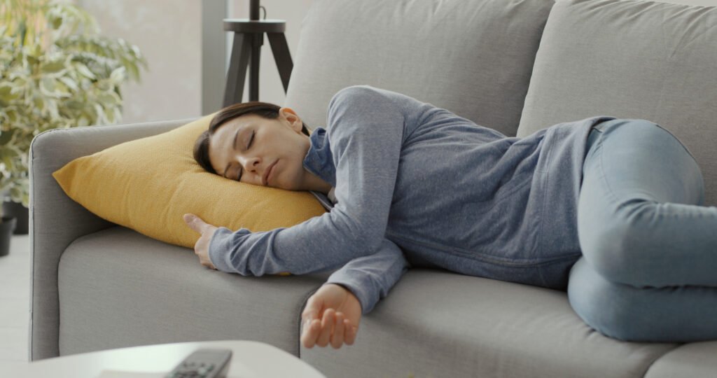 caregiver experiencing caregiver fatigue and exhaustion resting on couch burnout symptoms