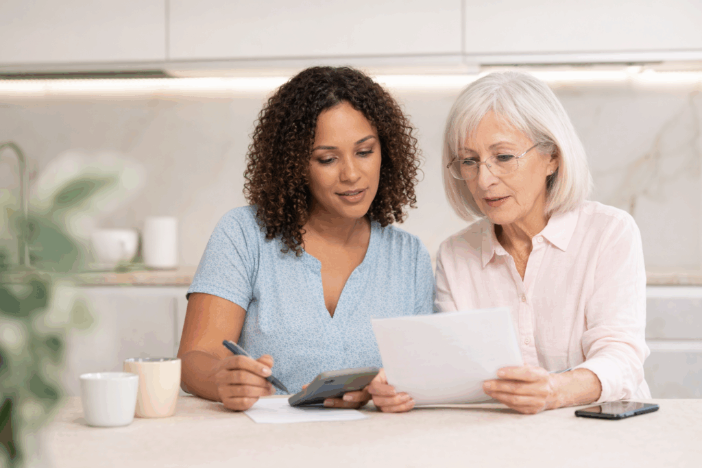 Adult daughter helping elderly mother review long-term care costs and documents
