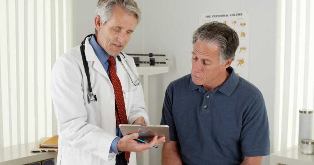 Man speaking with doctor during medical appointment