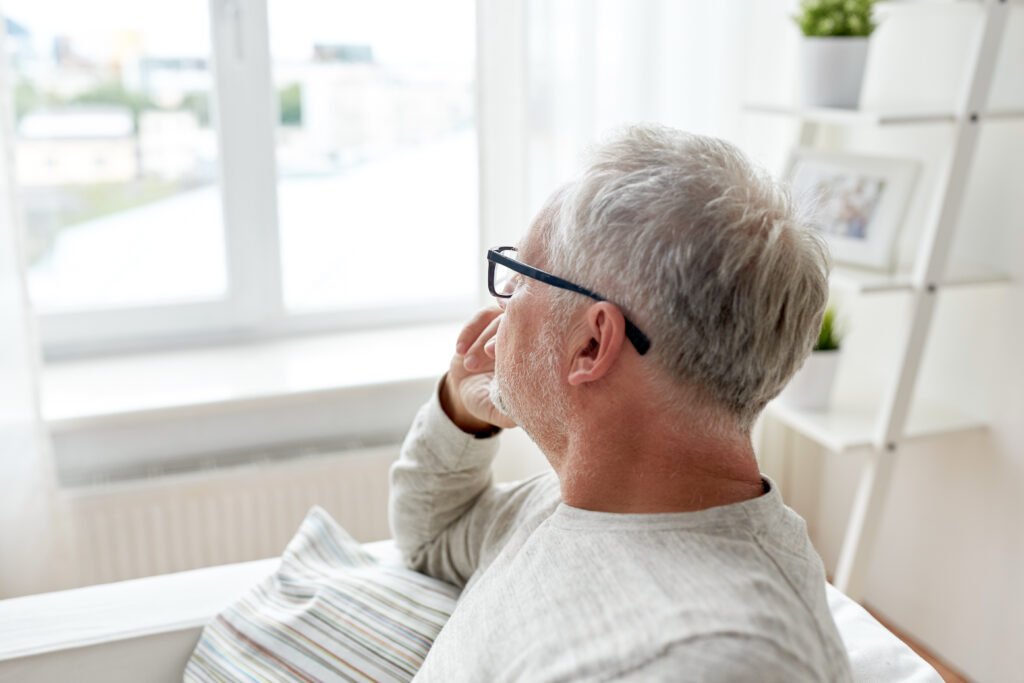 Man reflecting alone at home during emotional health struggles and aging