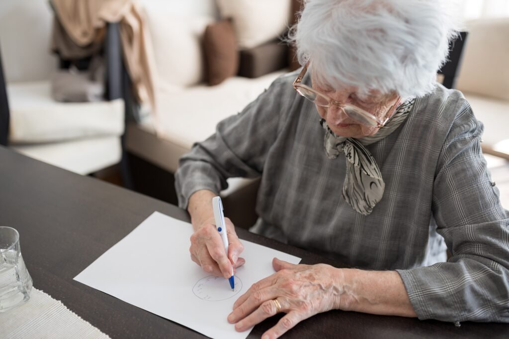 Senior woman completing a clock drawing cognitive assessment test used in Alzheimer’s disease evaluation and dementia screening