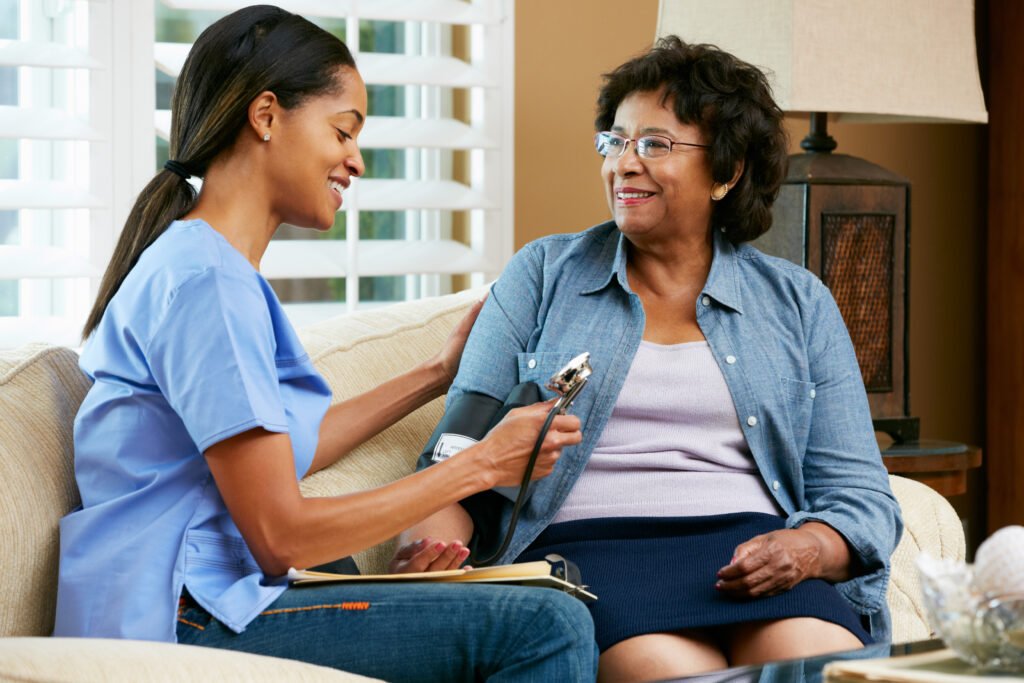 Home health care nurse checking blood pressure of senior woman during an in-home visit