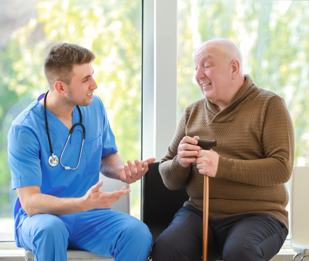 Older man speaking with a compassionate healthcare provider during palliative care support visit