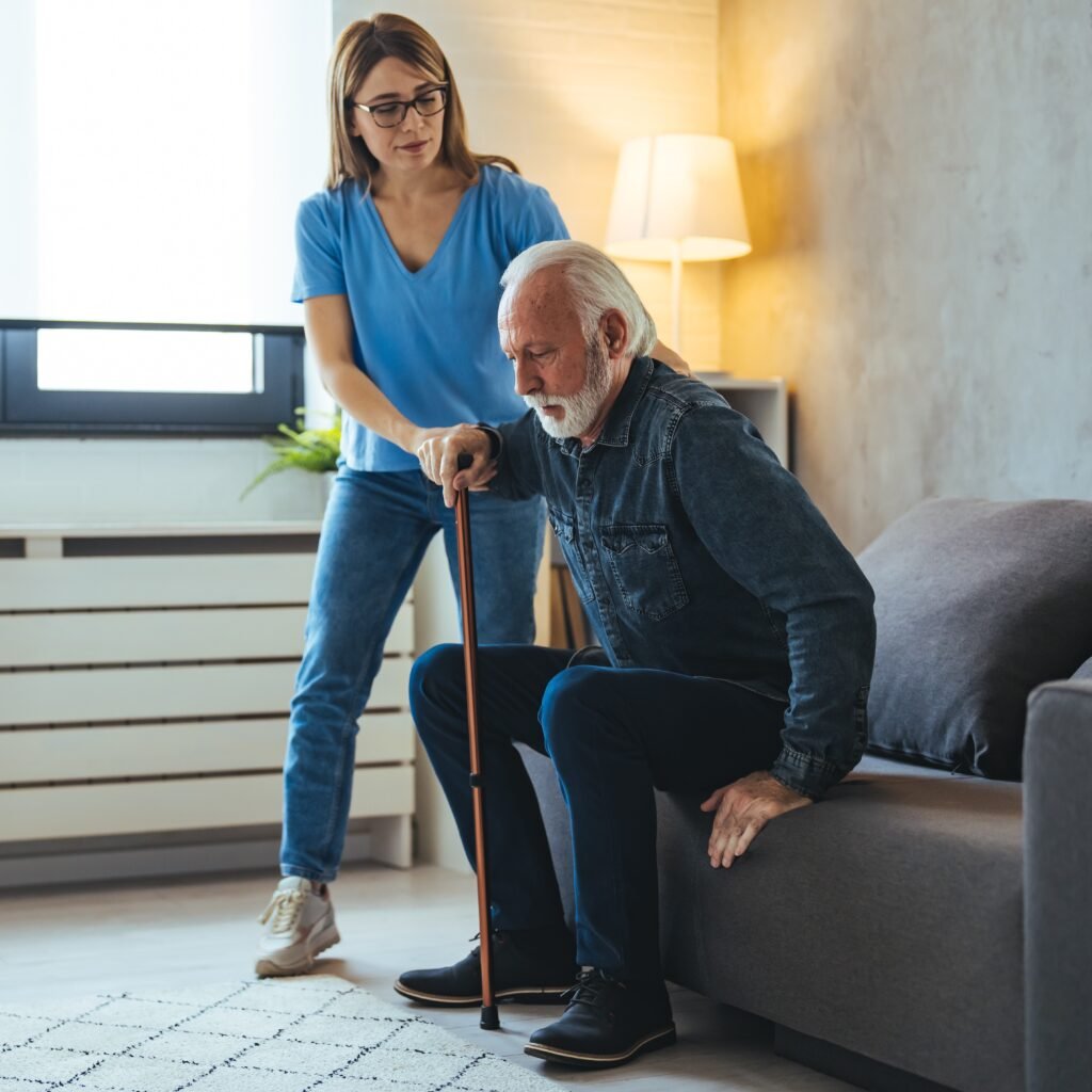 Caregiver assisting an older adult with mobility and balance support at home
