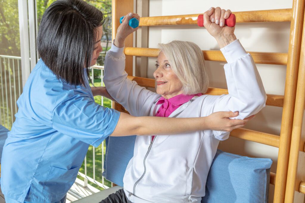 Senior woman participating in rehabilitation therapy with assistance from a healthcare professional in a skilled nursing facility