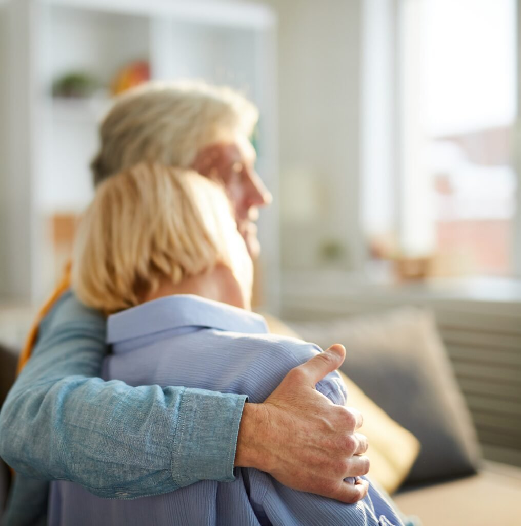 Family caregiver comforting a loved one with dementia by offering reassurance and emotional support.