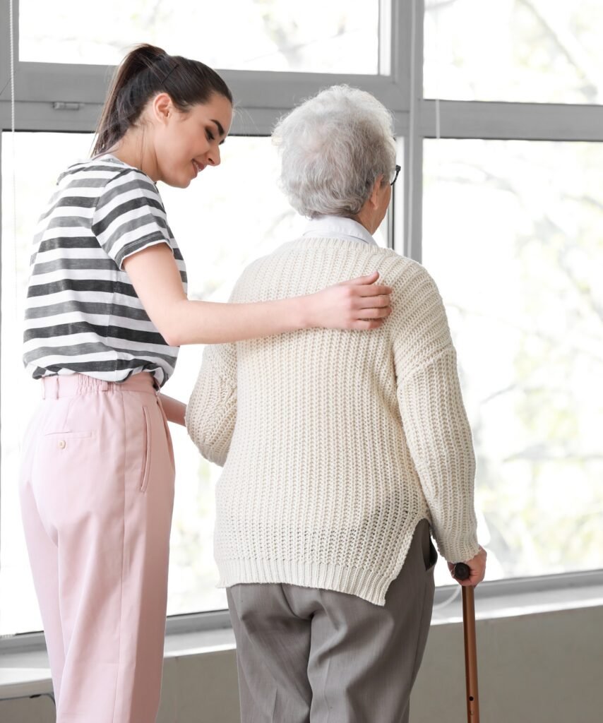 Caregiver assisting an older adult with mobility during 24/7 home care