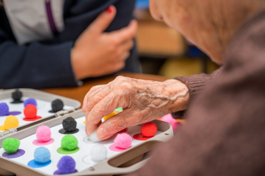 Older adult participating in a structured activity with memory care and dementia staff