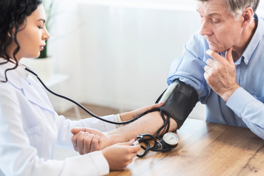 Older adult having his blood pressure checked by a healthcare professional