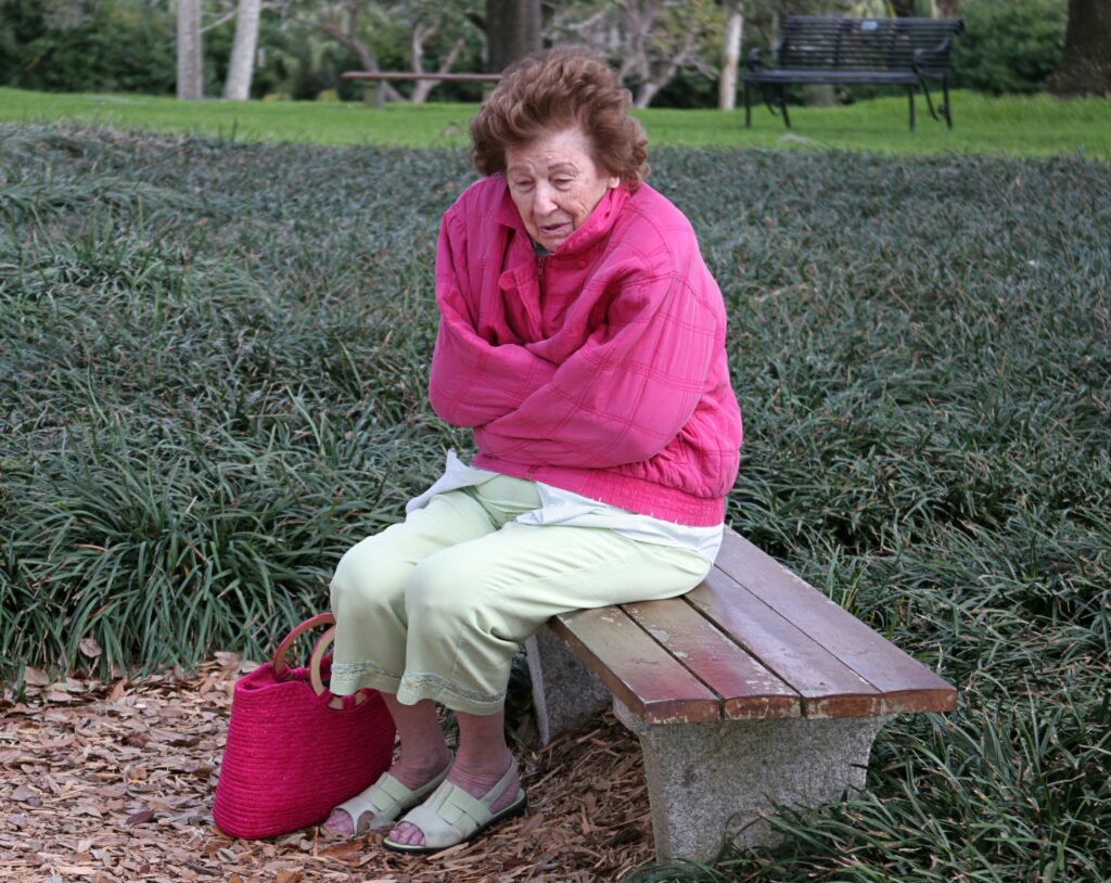 Older woman sitting alone outdoors, illustrating the risk of wandering and getting lost with dementia