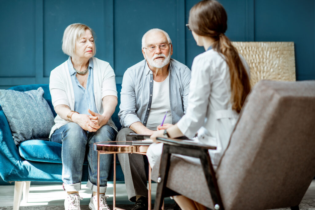 Older couple having a conversation with a senior healthcare professional about care and support options.